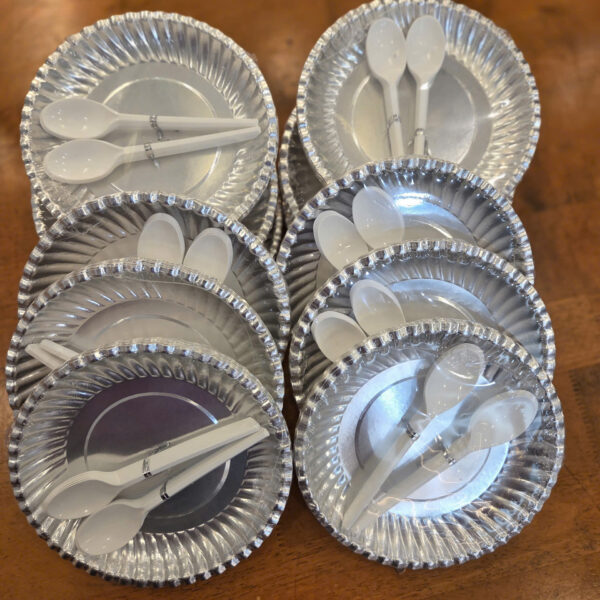 Đĩa giấy bạc và muỗng nhựa trắng