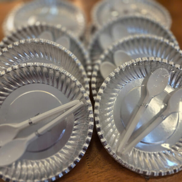 Đĩa giấy bạc và muỗng nhựa trắng